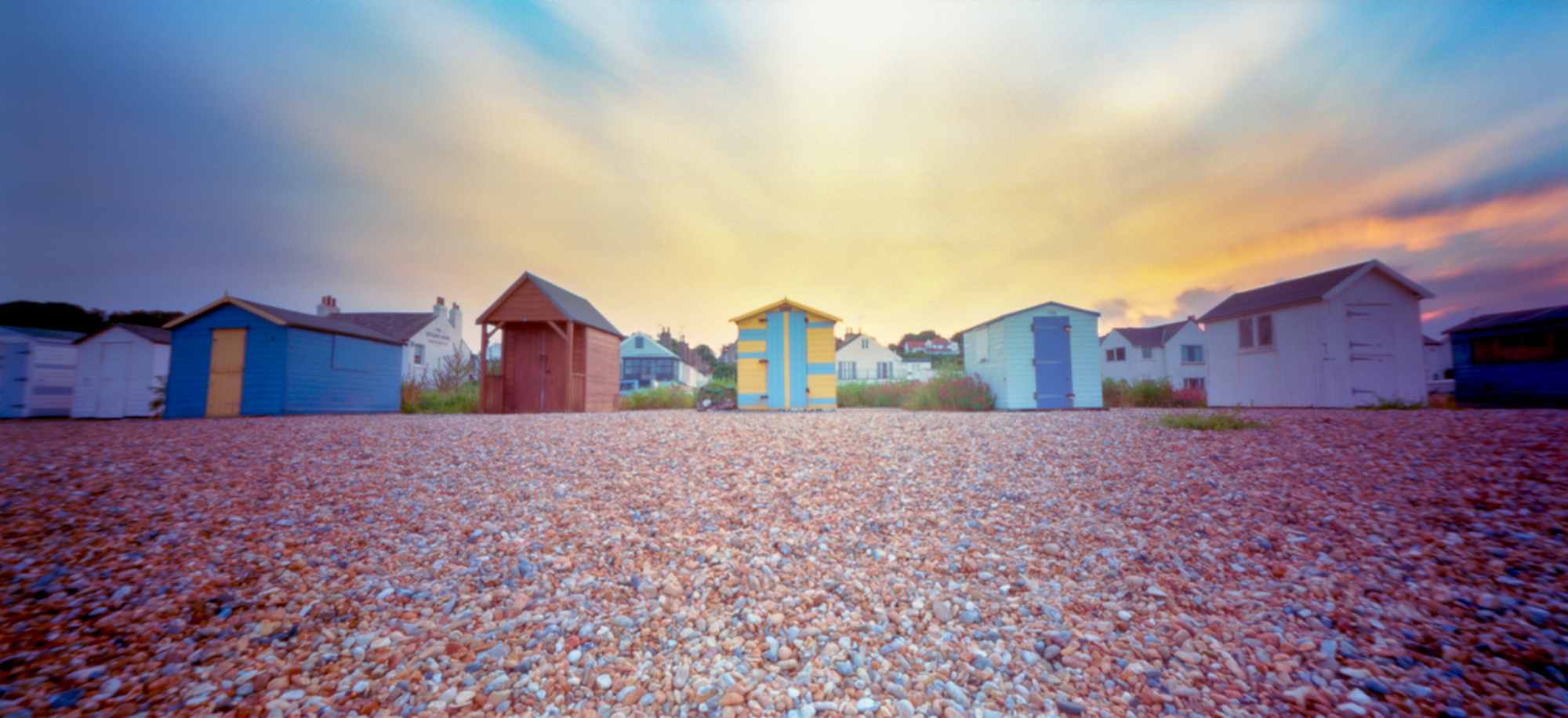 Colour pinhole of a beach and seaside huts.